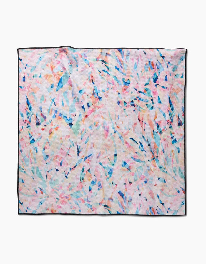 The Rachel Parker Abstract Jungle Dog Towel features a square shape with a colorful abstract leaf pattern in pink, blue, and orange, thin black edging, and is highly absorbent and quick-drying. Shown on a white background.