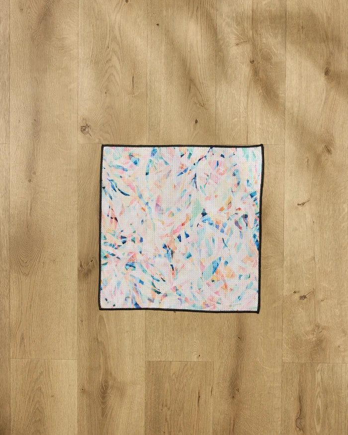 The "Abstract Jungle" by Rachel Parker is a square, pastel-patterned, ultra-absorbent dog towel with a black border, shown on a light wood floor.