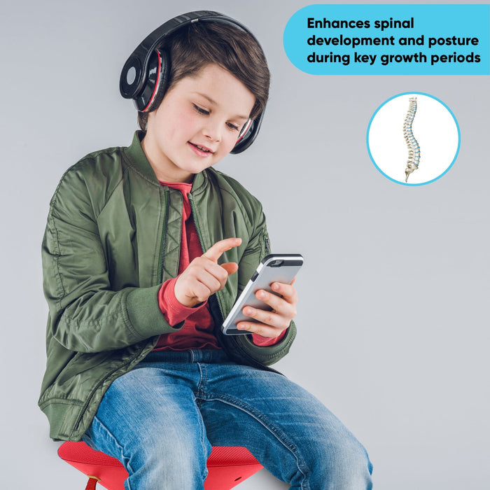 Child on red adjustable wobble chair for kids, using phone, promoting posture benefits.
