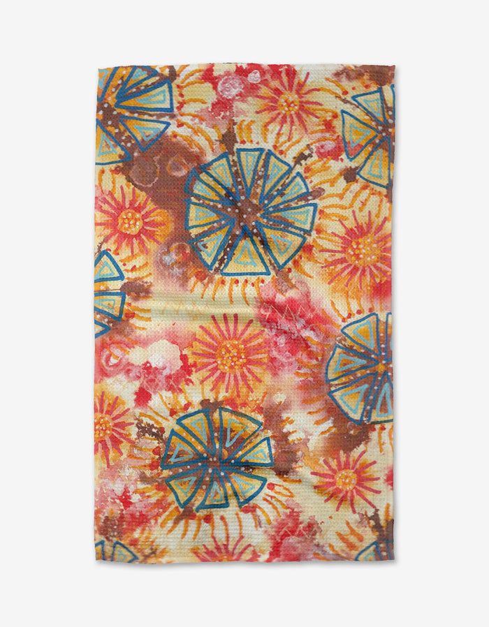 The African Loose Circles tea towel by Taryn Brennan features a vibrant, artistic abstract pattern of blue and orange circles with yellow sunbursts on a cream background.