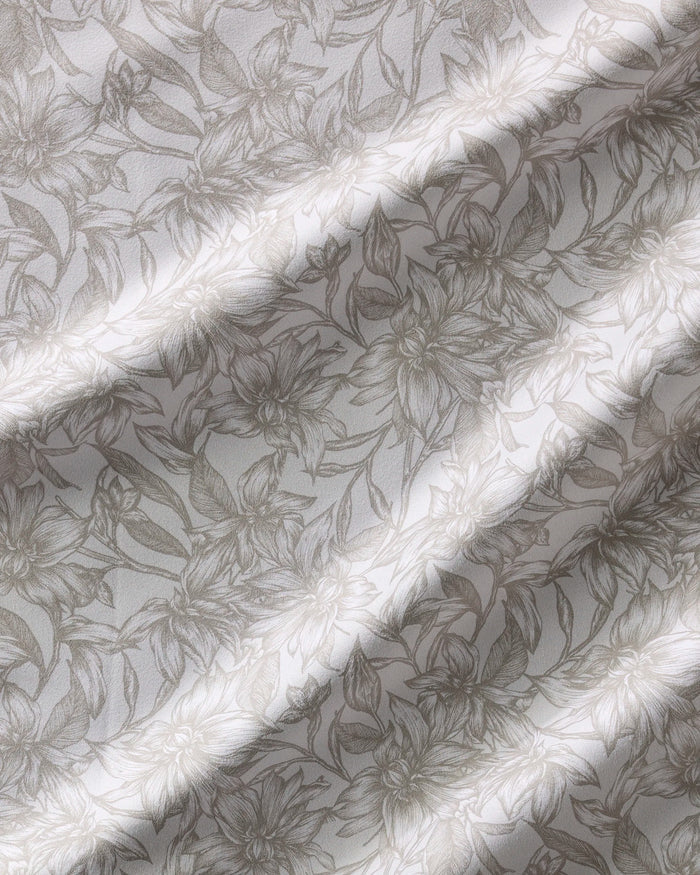 The Alba napkin set by Geometry features beige and white fabric with a floral line-art pattern. Soft, natural folds and a subtle sheen create gentle shadows, enhancing the intricate flower design. Absorbent and stylish for any table setting.