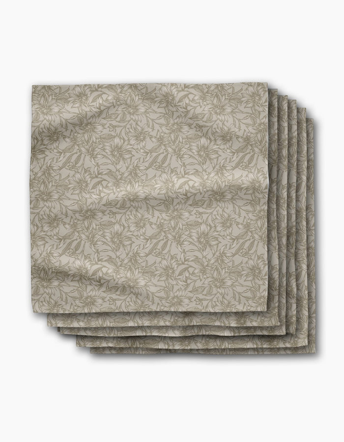 A set of six neatly folded Alba dinner napkins by Geometry, featuring a subtle floral pattern in beige—perfect reusable and stylish napkins for sustainable dining.