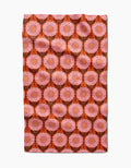 The Amy MacCready Amber tea towel is made from recycled materials and features large pink and orange flowers with black stems on deep orange, forming a symmetrical, ultra-absorbent surface.