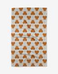 The Amor tea towel by Danelys Sidron features a repeating orange heart and arrow pattern in neat rows. Made from quick-drying recycled materials.