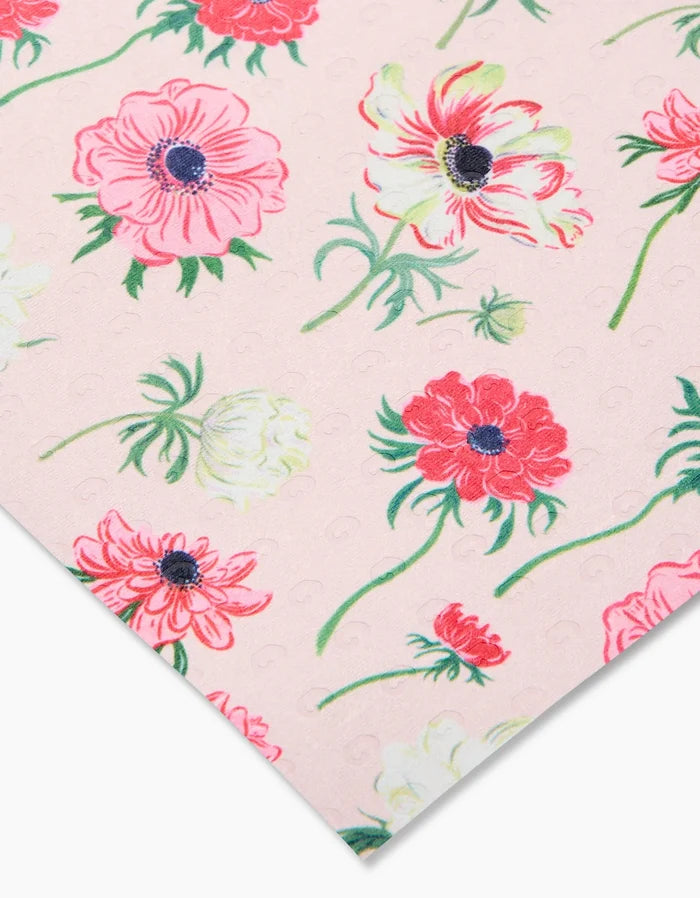 Close-up of Anemone Garden Flowers fabric by Linda Fox, showing red, pink, and white floral patterns with green leaves on a pink background. Eco-friendly and made from post-consumer recycled materials—not paper towels.