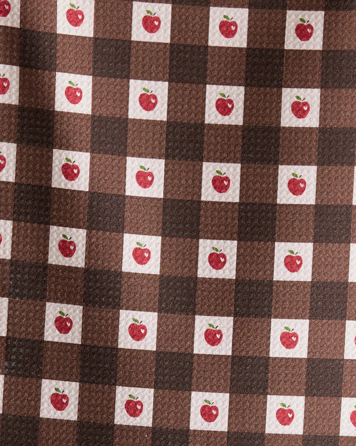 The Geometry Apple Picnic bar towel features a brown and dark brown checkered pattern with small red apples and green leaves in some white squares. Ultra-absorbent and textured, it combines style with function.