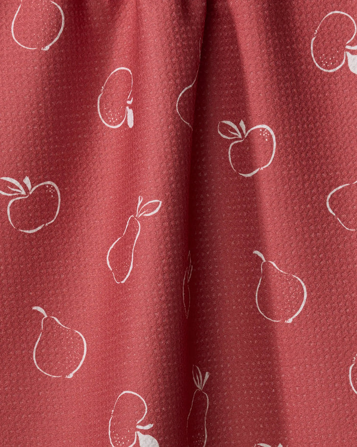 The Apples and Pears tea towel by Linda Fox features soft red fabric with a subtle texture, accented by simple white line drawings of apples and pears—an attractive and quick-drying addition to any kitchen.
