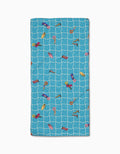 The At The Pool beach towel by Geometry features a rectangular blue Geoweave fabric with a white grid and colorful illustrations of people swimming and relaxing on pool floats.