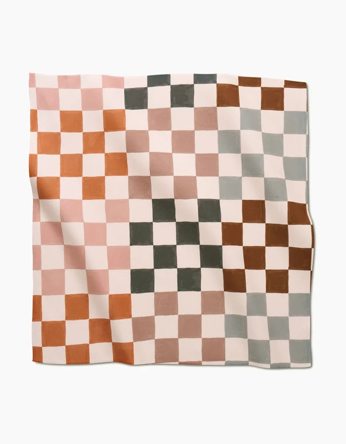 The Autumn Checkers cloth by GEOMETRY features a wavy Geosuede surface and a checkered pattern in muted pink, green, brown, and cream, with alternating colored squares across the fabric.
