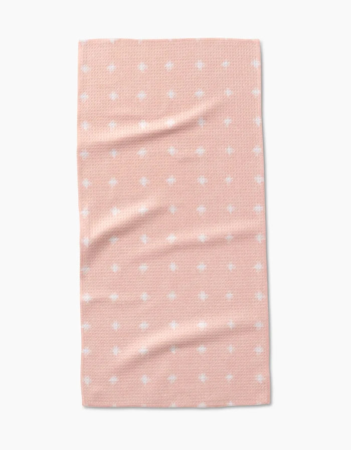 The Amy MacCready Aveline towel is a rectangular, peach-colored bar towel made from ultra-absorbent Geoweave fabric with a textured pattern and evenly spaced small white dots, displayed on a plain white background.