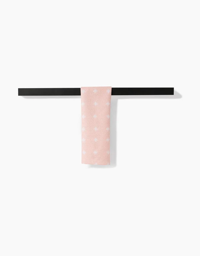The Amy MacCready Aveline towel, in light pink with white polka dots, hangs neatly on a simple black towel bar against a plain white background.