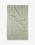 The Kailee Wright Avocado towel, featuring green and white stripes and made from ultra-absorbent Geoweave fabric, is laid flat on a white background with slight surface wrinkles.