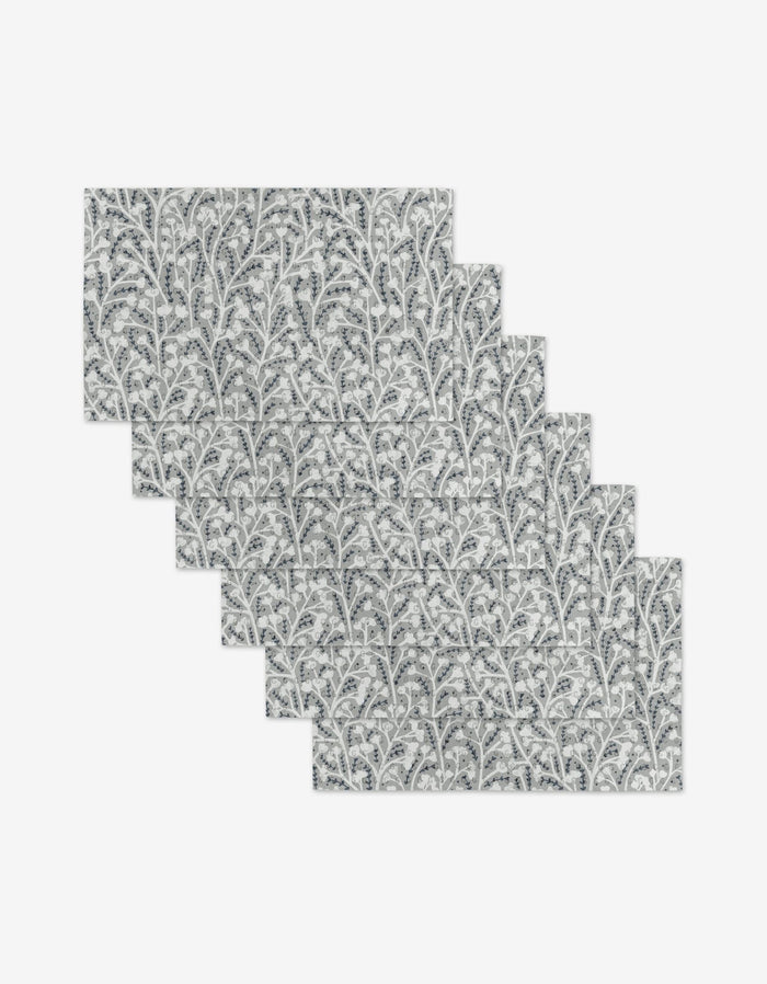 The Babys Breath placemats by Katie OShea include six reusable rectangular mats featuring a gray and white leafy branch pattern—an eco-friendly alternative to paper towels.