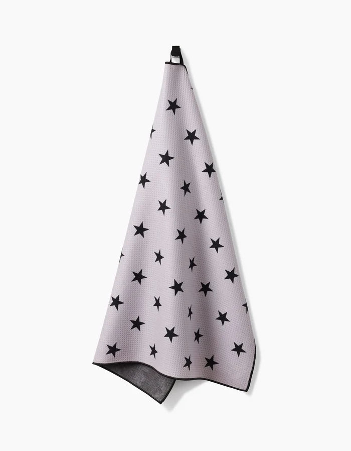The Geometry Bark towel, in light gray with black stars and a black hanging loop, is highly absorbent and displayed against a white background.