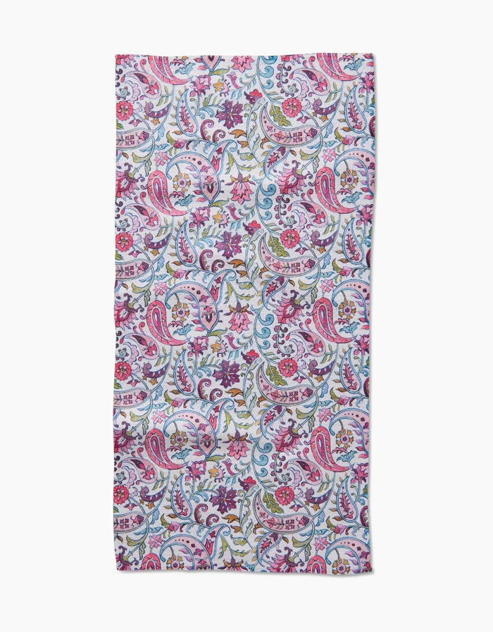 The Bazaar bar towel by Maayan Alper-Swan is made from ultra-absorbent Geoweave fabric, showcasing a vibrant floral and paisley design in pink, blue, green, and white tones. It is displayed flat on a white background.