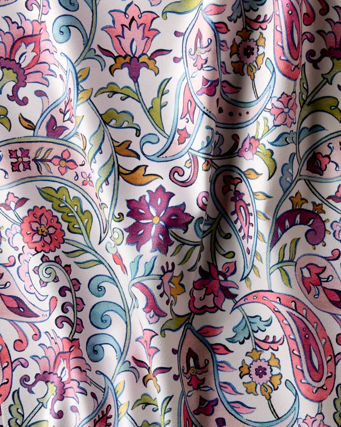 A close-up of Bazaar by Maayan Alper-Swan shows vibrant floral and paisley patterns in pink, blue, green, and red on white fabric—ideal for eco-friendly recycled dinner napkins or an absorbent cloth napkin set.