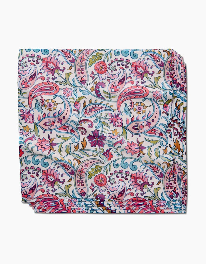 The Bazaar dinner napkin set by Maayan Alper-Swan features a vibrant floral and paisley pattern in pink, blue, green, yellow, and red on white, crafted from eco-friendly Geosuede fabric.