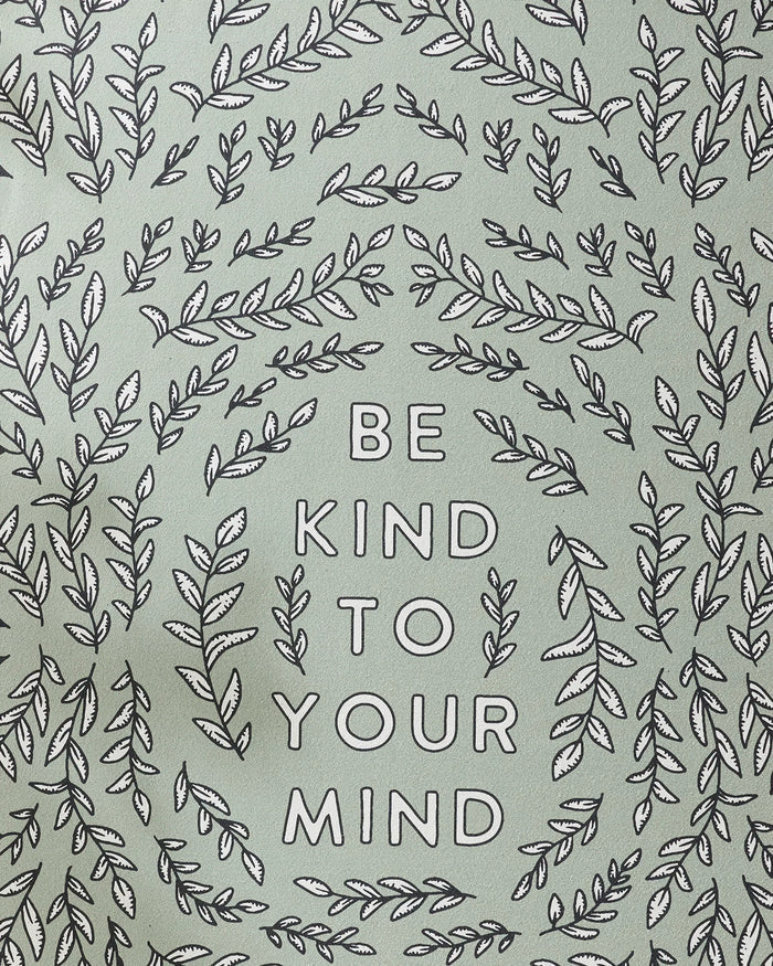 The image features BE KIND TO YOUR MIND in bold uppercase, framed by leafy branches on a light green background—perfect inspiration for your next yoga session with the Graphics and Grain Be Kind To Your Mind non-slip towel.