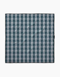 The Geometry Beach Storm blanket features a blue and white plaid pattern with alternating squares, a thin black border, and is made from recycled materials, shown laid flat on a white background.