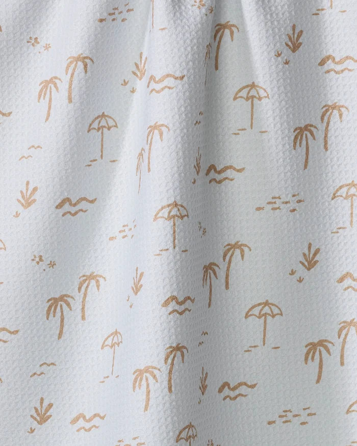 The "Beach" tea towel by Jen B. Peters features a white textured design with light brown palm trees, umbrellas, birds, waves, and grass—bringing a tropical beach vibe to your kitchen decor.