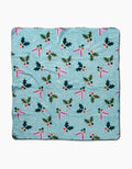 The Berries Mint dog towel by Megan Roy is a light blue, ultra-absorbent towel with holly leaves, red berries, and pink ribbons in a repeating pattern, shown flat on a white background.