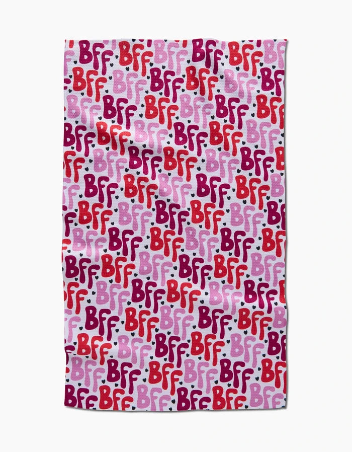 The Best Friends Forever blanket by Hufton Studio features a repeating BFF pattern in red, pink, and purple text on a light pink background with white dots, styled like a charming tea towel for cozy moments.
