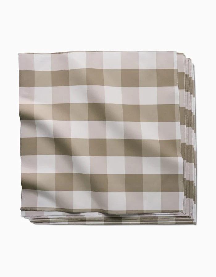 The GEOMETRY Betty Bakes folded cloth napkin, made from Geosuede fabric and featuring a beige and white checkered pattern, is displayed against a plain white background.