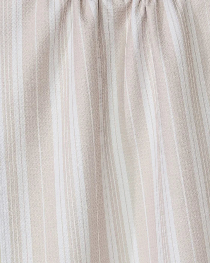 The GEOMETRY Betty Beach kitchen towel features light beige and white vertical stripes, gathered to create a soft, textured pattern with gentle folds and shadows.