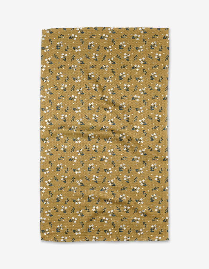 Betty by Charlie Rowan Designs is a mustard yellow Geoweave™ fabric with small white flowers and green leaves, shown flat against a white background with some visible creases.