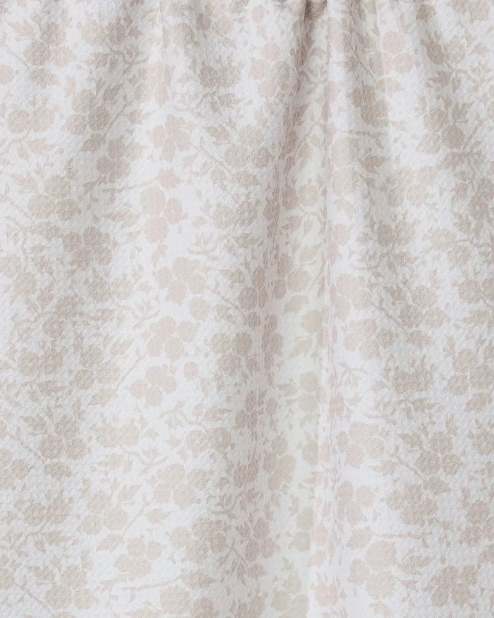 A close-up of GEOMETRYs Bettys Buds, a light beige tea towel made from recycled materials, featuring a subtle floral pattern and gentle gathered folds near the top.