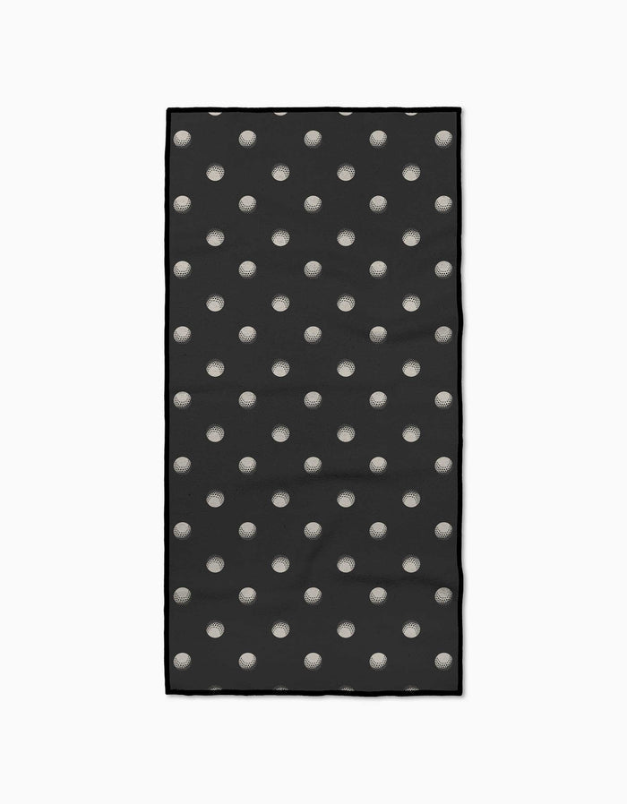 Geometry’s Birdie towel is a black rectangular fitness towel with evenly spaced white polka dots, bordered by a thin black line. Crafted from recycled materials, it’s ultra-absorbent and shown on a plain white background.