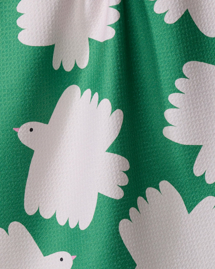 Birds by Jennifer Bouron features white, cartoon-style birds with pink beaks on a textured green tea towel. Its quick-drying fabric offers practicality, while playful designs and gentle folds add a whimsical charm to your kitchen.