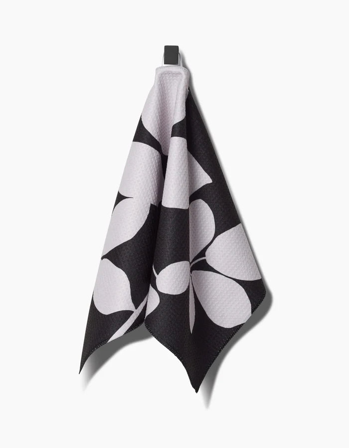 PrintedPlants Blackberry bar towel, crafted from durable Geoweave fabric, features a bold black and white abstract leaf pattern and hangs from a hook against a plain white background.