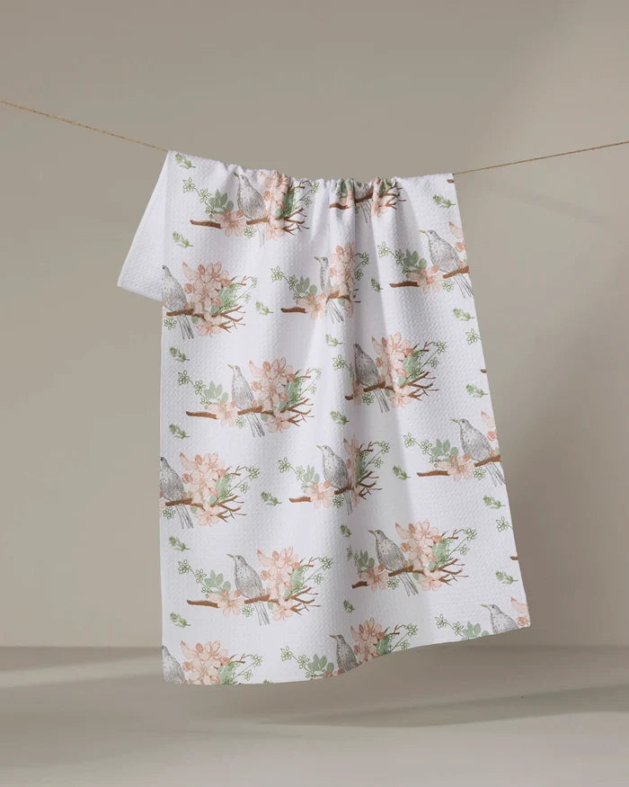 The "Blackbird and Blossom" recycled kitchen towel by Linda Fox features birds on flowering branches, draped against a neutral background.