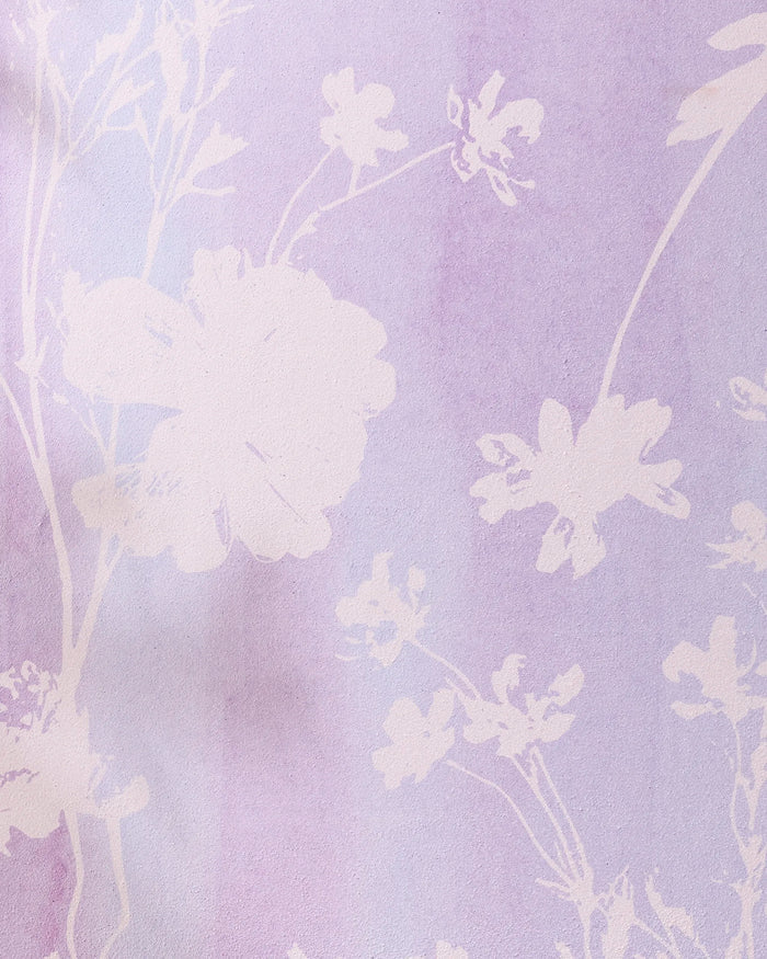 The GEOMETRY Bloom Blend yoga towel features light floral silhouettes on a soft pastel lavender base with gradient shading, offering a delicate and dreamy design.