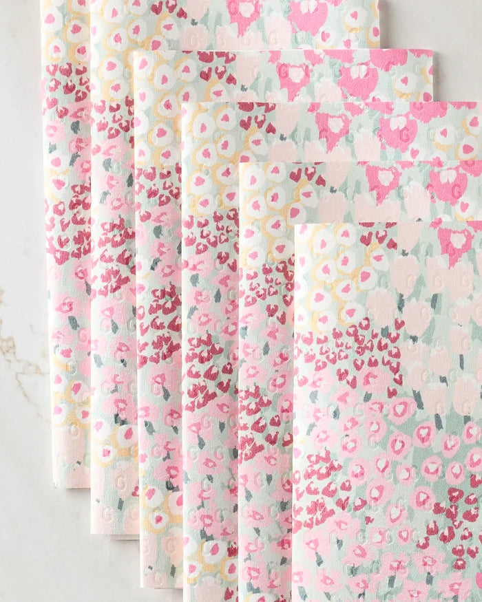 Six Bloomed For Spring reusable paper towels by Hufton Studio are fanned out on a light surface, featuring pastel pink, yellow, and soft green abstract floral patterns for a delicate, spring-inspired look.