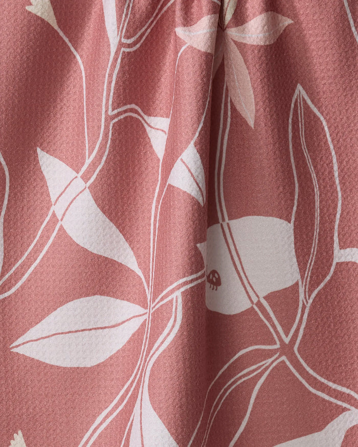 Close-up of the Blooms tea towel by Elana Gabrielle, featuring a pink ultra-absorbent fabric with a white abstract botanical pattern and dimpled texture—stylish and functional for any kitchen.