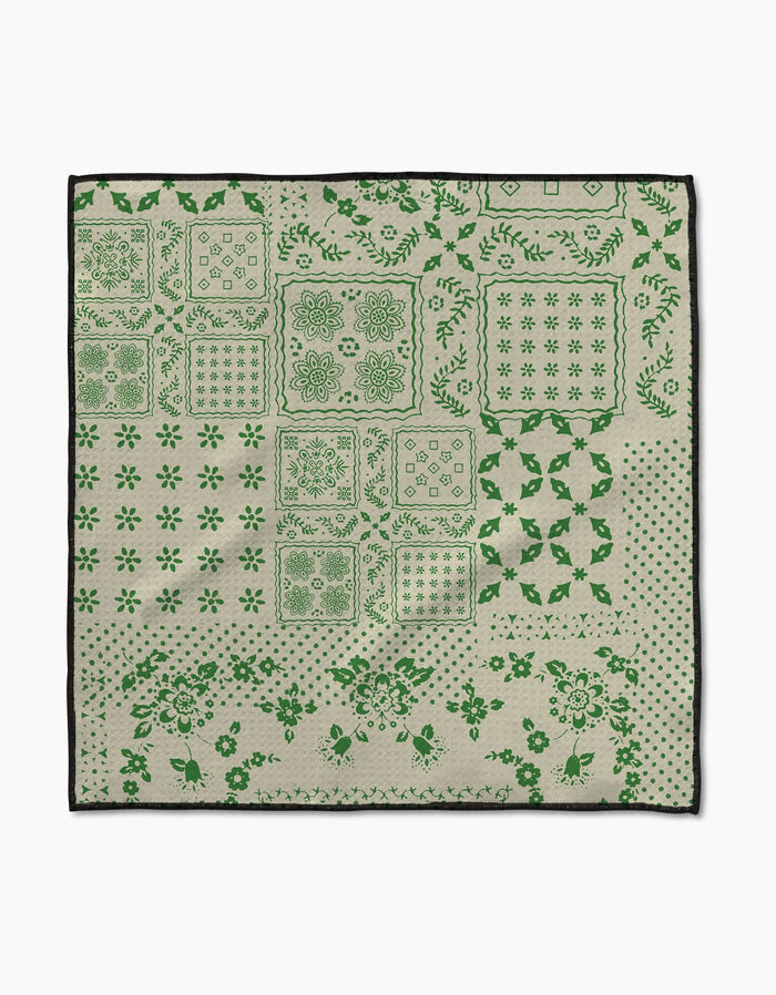 The Blossoming Bandanna Green by Geometry is a square beige cloth made from ultra-absorbent Geoweave™ fabric, featuring green floral, geometric, and dotted patterns in blocks with a black border. Ideal as a pet Paw Towel.