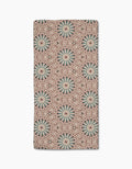 The Katherine Berkeley Blue Aster Foxtrot Bar Towel features ultra-absorbent Geoweave fabric and a kaleidoscopic pattern of blue and red starbursts on beige for a bold, symmetrical look.