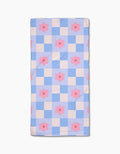 The Blue Checkered Florals quilt by Letters By Shells features a blue and white checkered pattern with evenly spaced pink flowers, crafted from recycled materials for an eco-friendly design.