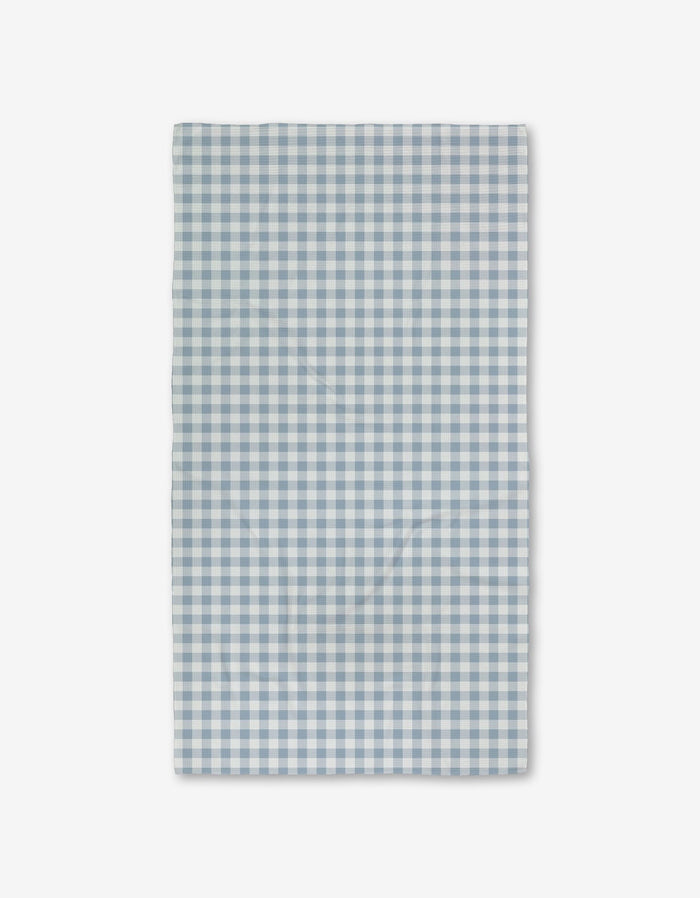 The Aubrey Fairchild Blue Gingham Luxe Bath Towel features a blue and white check pattern and ultra-absorbent Geoweave technology, shown flat on a white background.