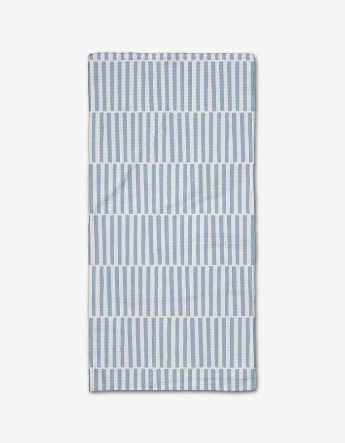 The Blue Stripes Bar Towel by Aubrey Fairchild features vertical blue and white stripes in horizontal bands on a white background, crafted from Geoweave fabric and neatly folded on a white surface.