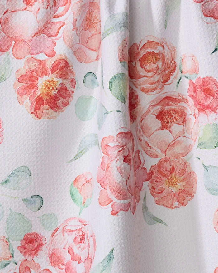A close-up of the Elena Fay "Blush Florals" kitchen towel, made from recycled materials and featuring pink and peach watercolor-style flowers with green leaves on a white textured background.