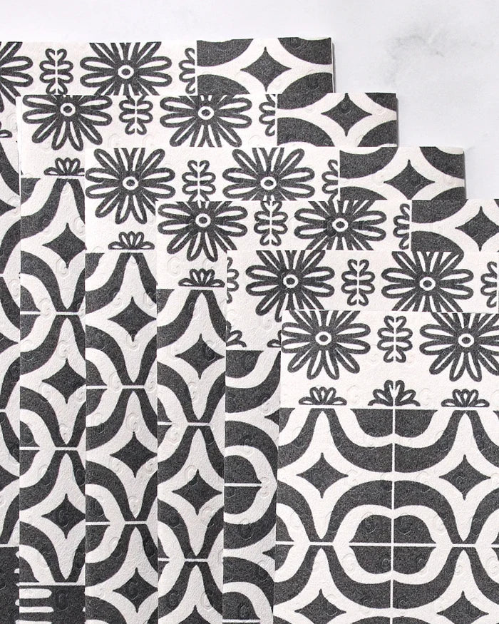 Bohemian Mosaic by GEOMETRY features overlapping rectangular tiles with black and white geometric and floral patterns, arranged in a stepped layout on a light background—perfect for stylish reusable paper towels.