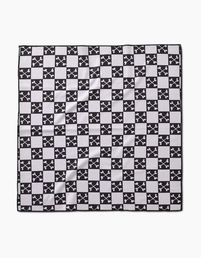 The Boneyard Black Checkerboard by Charlie Rowan Designs is a square dog towel made from recycled materials, featuring a black and white checkerboard pattern with crossed-swords emblems and a textured, eco-friendly feel.