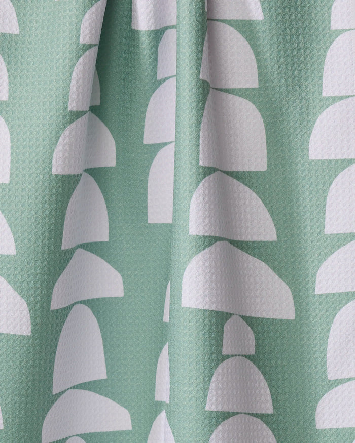 Breakfast at Granny's by Claire Iglesias is a textured green tea towel made from recycled materials, featuring white semi-circular arches in vertical rows. Its softly gathered fabric adds stylish folds for an eco-friendly look.