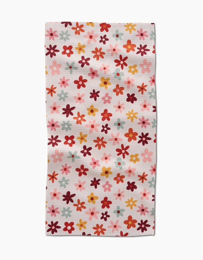 The Bright Field Of Fall Daisies by Sara Mari is a rectangular, ultra-absorbent towel adorned with small daisies in red, orange, pink, and yellow on a white background—ideal for brightening up any space.
