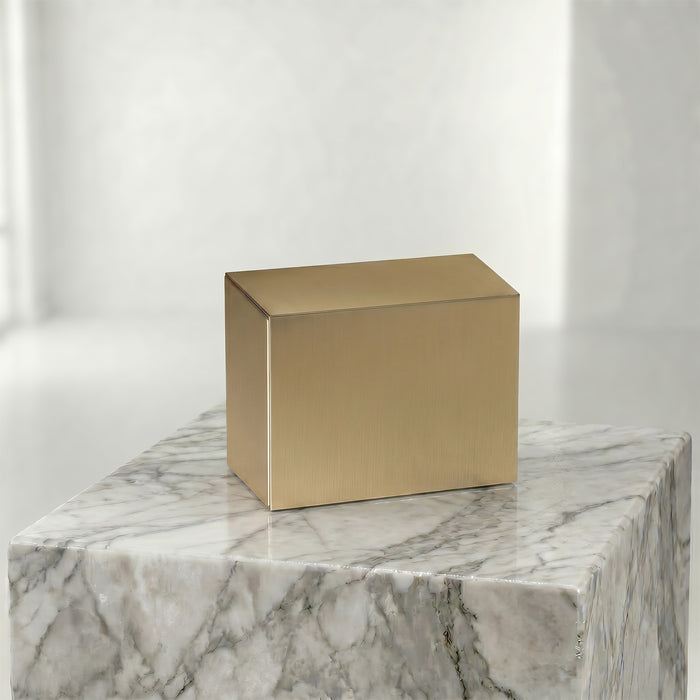 Bronze urn insert on a marble surface with a white background