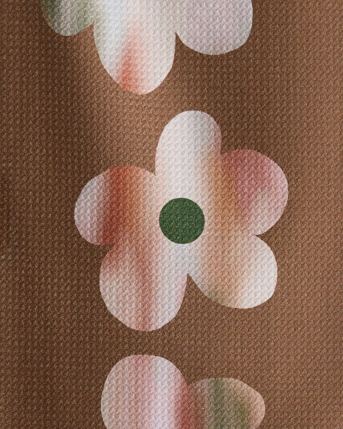 A close-up of Geometry’s Brushed Bouquet Brown shows its brown textured fabric with large white and pink flowers plus dark green centers—an ultra-absorbent, stylish recycled kitchen towel.