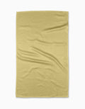 A Butter Yellow Kitchen Tea Towel by GEOMETRY, made from soft Geoweave™ fabric, is laid flat on a white surface, showing gentle creases and folds.